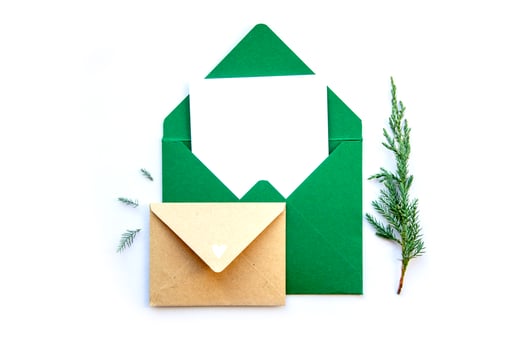 Crafty green envelope and letter with sprigs of evergreen on a white background for holiday greetings and seasonal projects photo