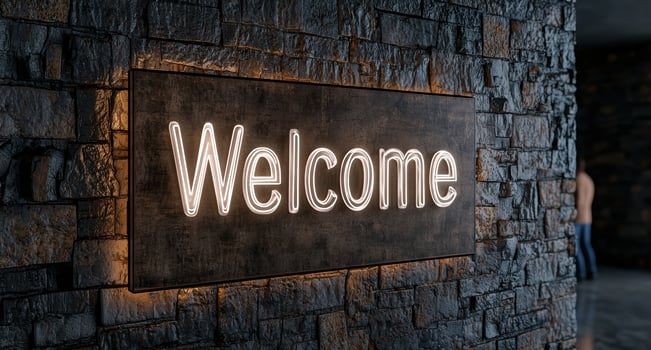 A neon welcome sign on a stone wall photo