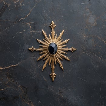 Elegant gold sunburst brooch with black gem on dark marble background photo