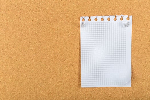 Blank grid paper pinned on corkboard ready for notes or ideas photo