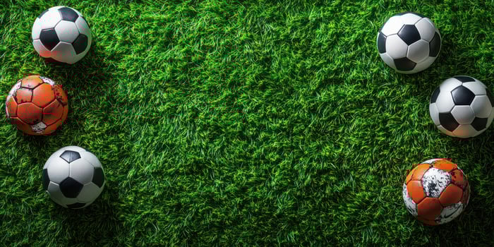 Soccer balls arranged on vibrant green grass before an upcoming match or practice session in bright daylight photo