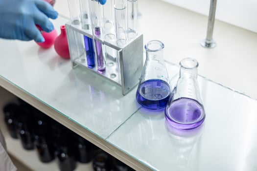 A person in a lab coat is holding a test tube photo
