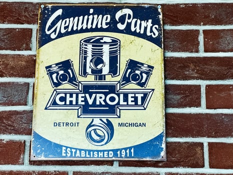 Lviv, Ukraine - February 13, 2025- Vintage Chevrolet sign displaying pistons and logo mounted on brick wall background photo