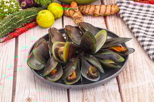 A plate of mussels with spices and vegetables photo