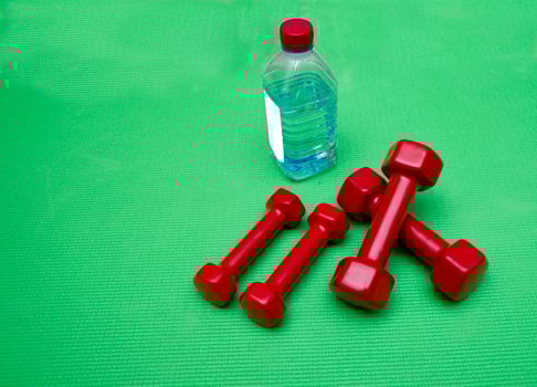 small dumbbells on green background photo