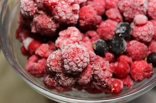 Defrosted Fruits Stock Photo. Frost On A Frozen Berries In A Glass Bowl photo