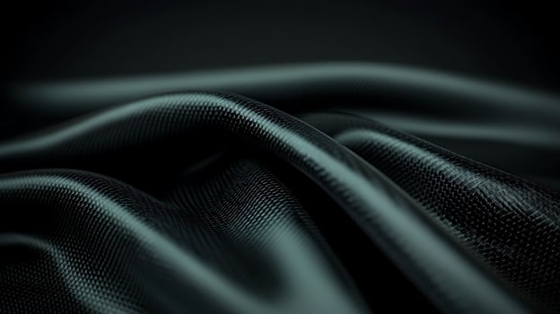 Close-up of smooth, flowing black fabric with subtle texture against a dark background photo