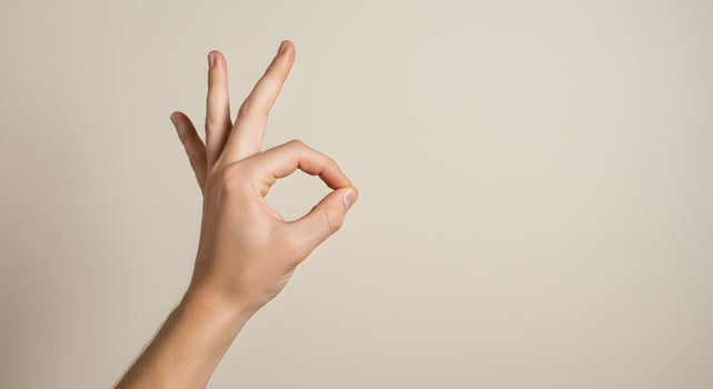 A Close-up Shot of a Hand Forming the Okay Sign Against a Neutral Background A Simple Gesture of Approval and Agreement photo