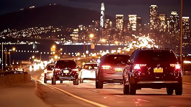 Nighttime cityscape with illuminated skyline and busy highway filled with vehicles photo