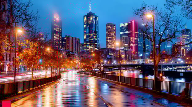 Nighttime cityscape of Melbourne with illuminated skyscrapers reflecting on wet roads photo