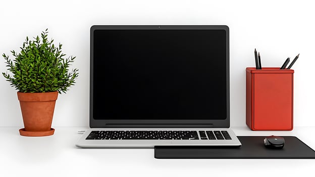 Modern workspace featuring a laptop, potted plant, and stationery on a clean desk photo