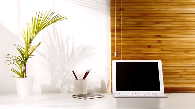 Modern workspace featuring a tablet on a desk with a plant and wooden wall background photo