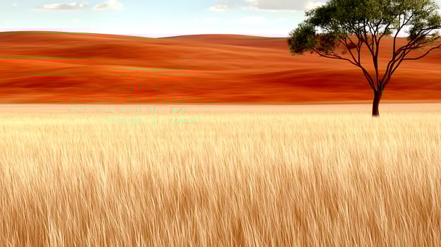 Serene landscape showcasing golden grass fields under a blue sky with distant red hills photo