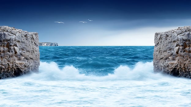 Serene seascape with crashing waves between rocky cliffs under a moody sky photo