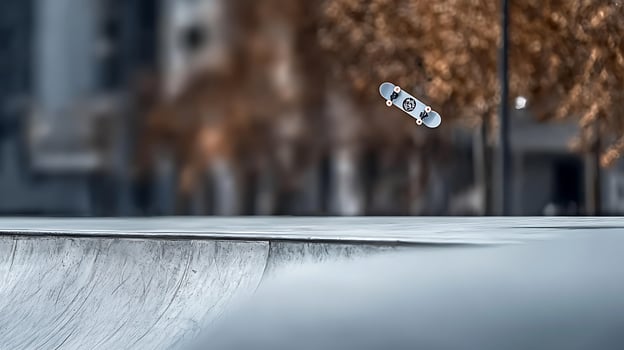 Skateboard performing an aerial trick above a concrete ramp in an urban skatepark setting photo