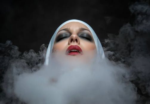 Mysterious woman with dramatic makeup surrounded by smoke photo