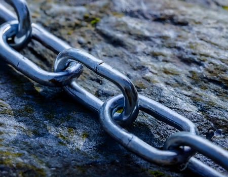 Aged Steel Chain on a Rugged Stone Surface photo