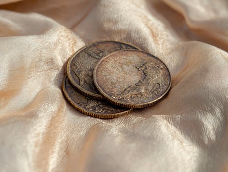 Three old coins on a golden fabric photo