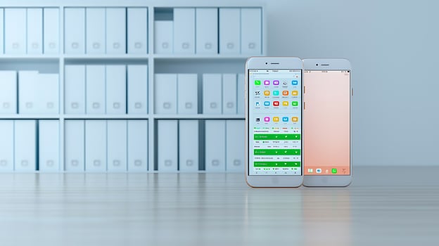 Two smartphones displaying different interfaces in a modern office environment with shelves photo