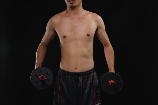 Young Man Holding Dumbbells Showcasing Strength and Health Focus photo