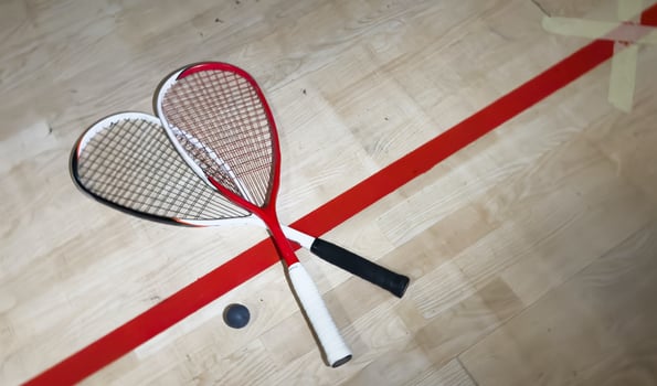 Squash rackets and ball on court floor, top view photo