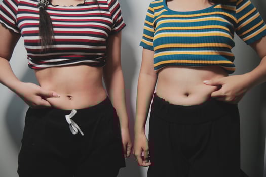 Two women standing next to each other with their stomachs photo