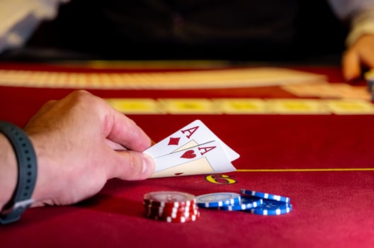 A person holding a pair of cards on a casino table photo