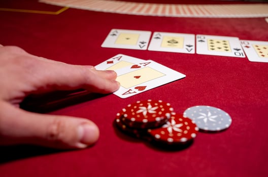 A person is holding a card and playing cards photo