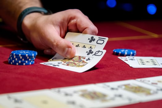 A person holding a pair of cards and playing cards photo