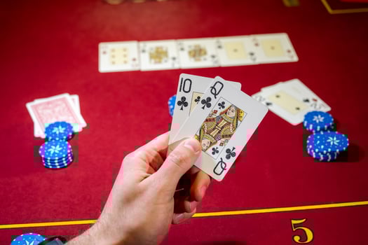 A person holding up cards on a casino table photo