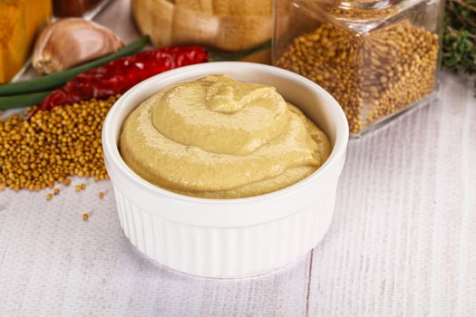 A bowl of mustard and spices on a table photo