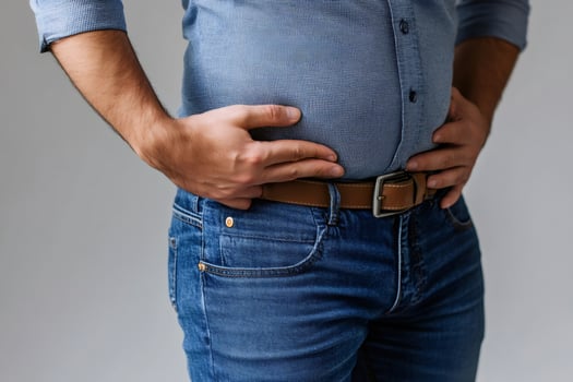 Overweight man touching big belly with hands, health problems concept photo