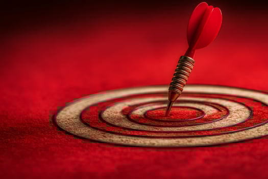 Red dart perfectly hitting the bullseye on target photo