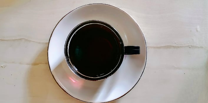 A black and white cup on a white plate photo