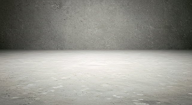 An empty room with a concrete wall and a cement floor photo