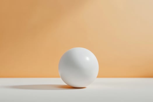 White spherical object resting on a light surface against a soft orange background during daylight photo