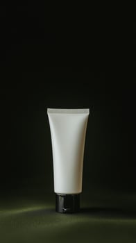 Minimalist white tube of cream on a dark background highlighting beauty product design at a studio setting photo