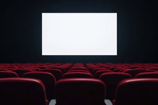 Empty cinema auditorium with rows of red seats facing a blank white screen, awaiting the show photo