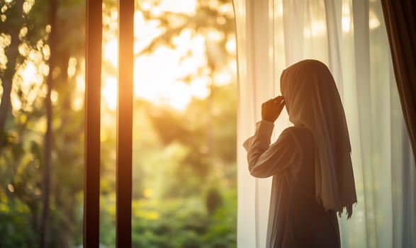 Woman by window, thoughtful, sunset view, interior, contemplation, stock photo