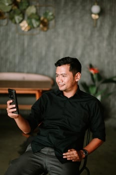 Relaxed asian man enjoys leisure time with his smartphone indoors serenity photo