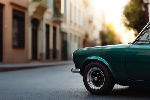 Classic green car parked on a quiet street at sunset with soft light illuminating the surroundings photo