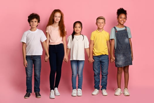 School friendship. Adorable multiethnic children holding hands together on pink background photo