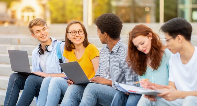 Diverse High-School Students Doing Homework Learning Together Sitting On Steps Outside. School Life Concept photo