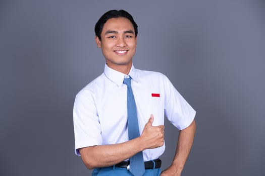 Indonesian Male High School Student in Uniform Giving a Thumbs Up Isolated Background photo