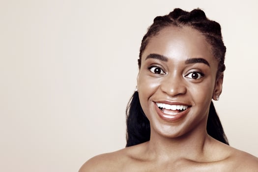 Closeup portrait of young emotional black woman posing over beige studio background, having romantic mood, smiling at camera, panorama with copy space. Millennials photo, lifestyle, emotions concept photo