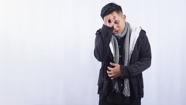 Asian Man Suffering from Fever and Chills on White Background photo