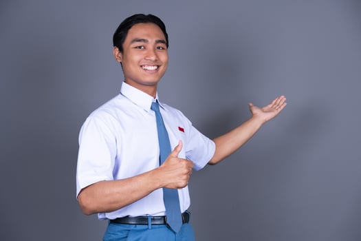 Indonesian Male High School Student in Uniform Presenting Gesture Isolated Background photo