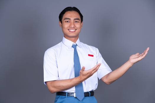 Indonesian Male High School Student in Uniform Presenting Gesture And Smiling photo