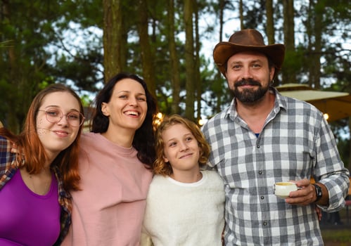 Family members father, mother and two daughters laughing in camping in the forest photo