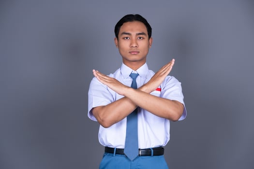 Indonesian Male High School Student in Uniform Showing Cross Sign Saying No photo